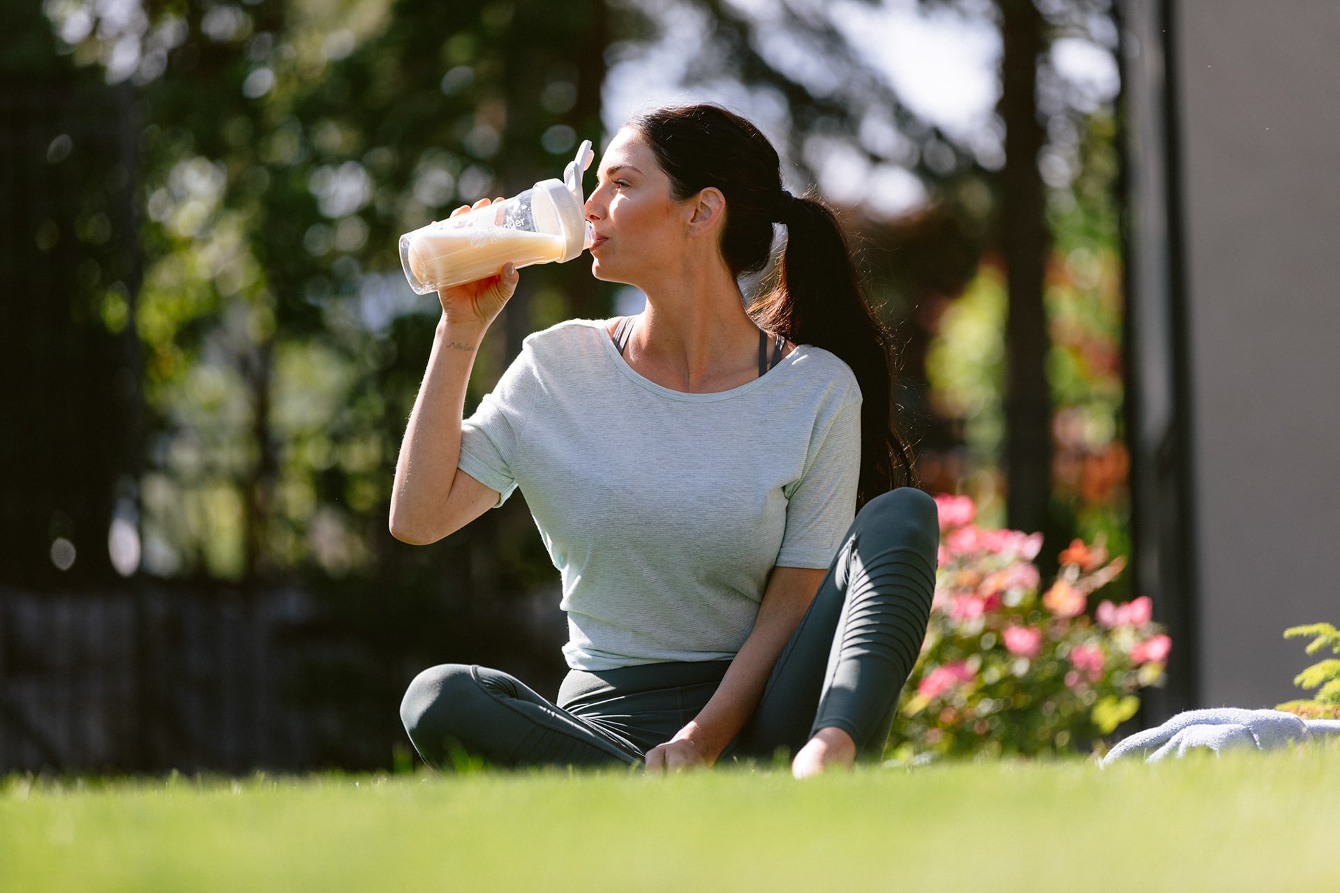 A woman enjoying a drink outside in the sunshine